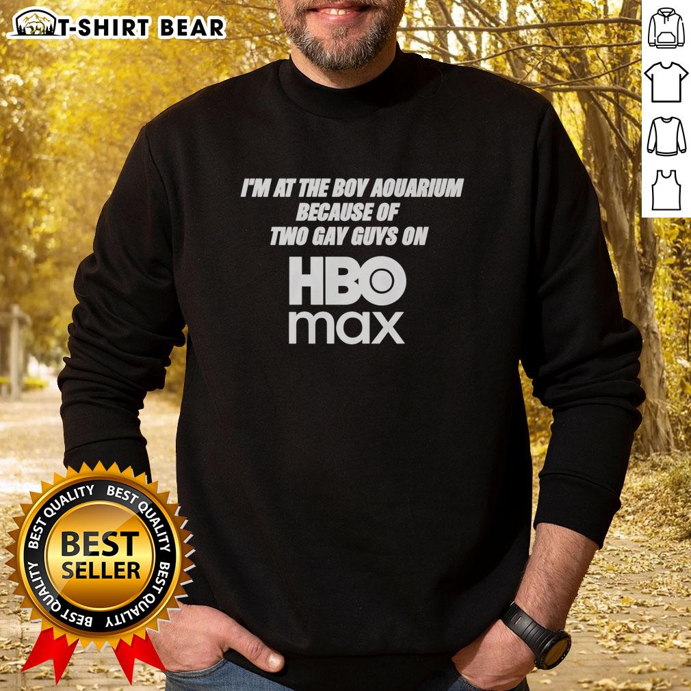 Man wearing 'Good I'm At The Boy Aquarium' sweatshirt, inspired by two gay guys on HBO Max, at a vibrant aquarium.