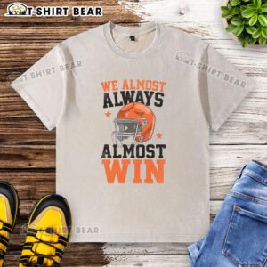 Alt Text: Funny football fan t-shirt reading 'Good We Almost Always Almost Win' in a casual, washed style.