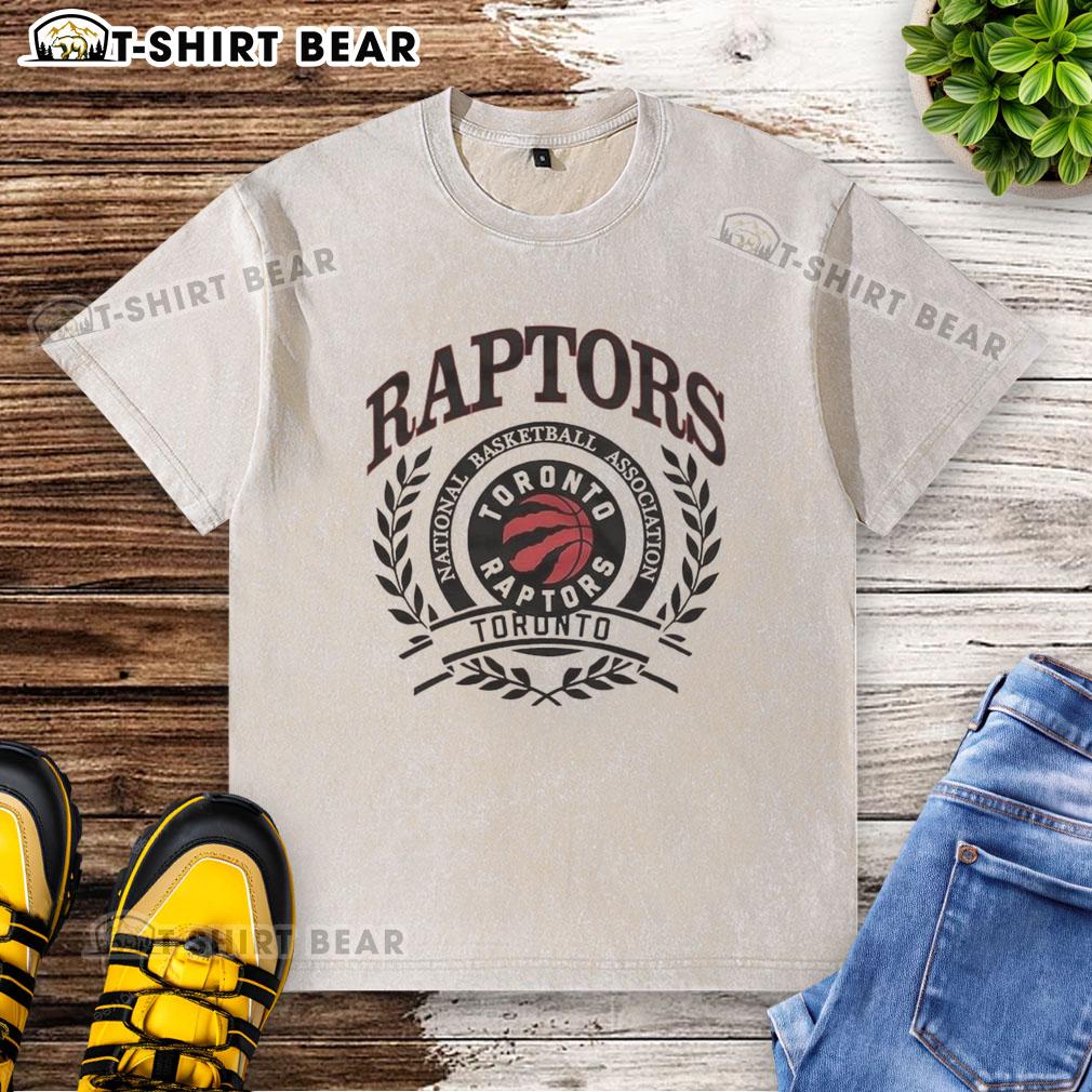 Retro washed t-shirt featuring the Toronto Raptors NBA logo framed by a laurel wreath, perfect for basketball fans.