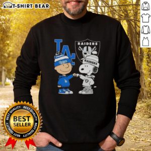 Original Charlie Brown fist bump with Snoopy on a Los Angeles sports sweatshirt featuring Dodgers and Raiders logos.
