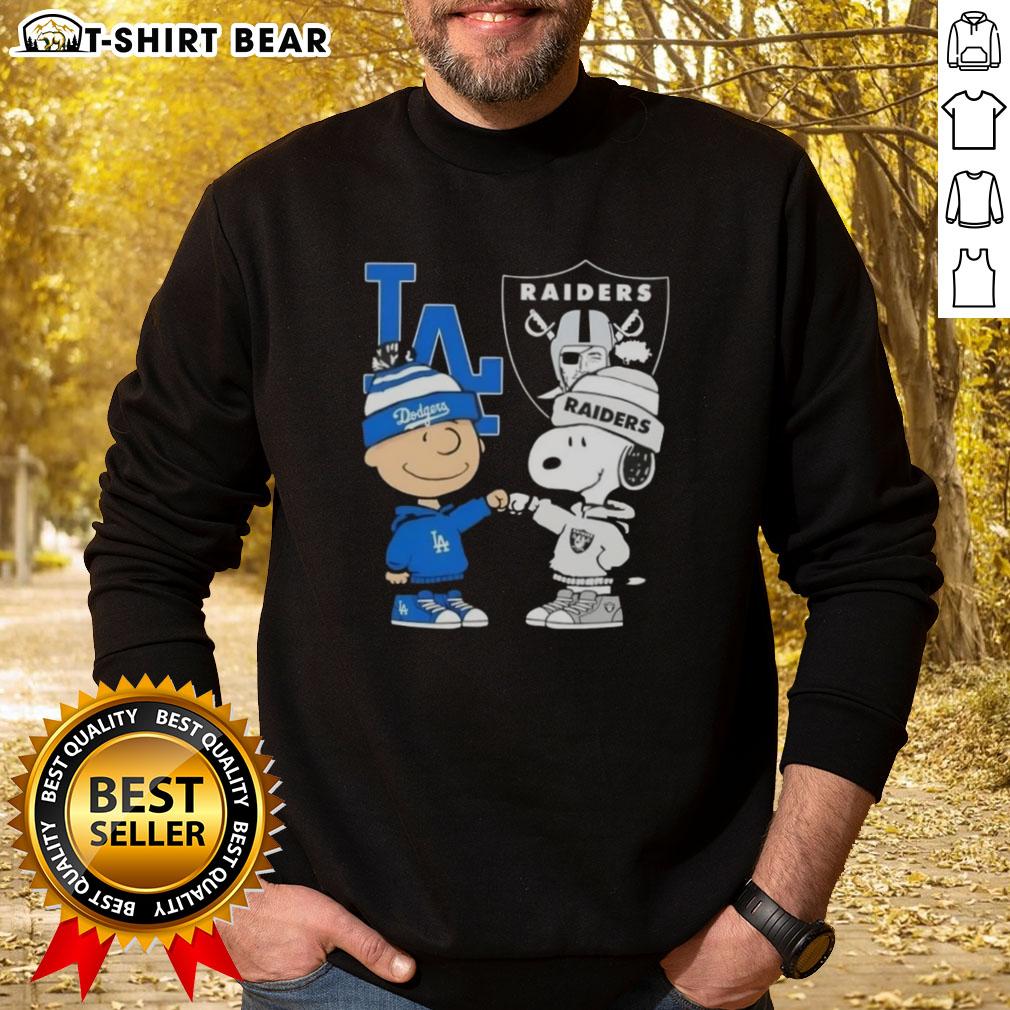 Original Charlie Brown fist bump with Snoopy on a Los Angeles sports sweatshirt featuring Dodgers and Raiders logos.