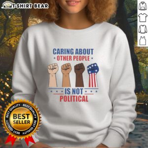 Premium sweatshirt with 'Caring About Other People Is Not Political' slogan, featuring bold fists design in vibrant colors.