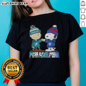 Top Charlie Brown and Snoopy Philadelphia City Sports Eagles X 76ers ladies tee featuring iconic characters and team logos.