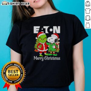 Alt Text: Ladies' tee featuring Eaton Corporation X Grinch and Snoopy designs for a merry Christmas celebration.