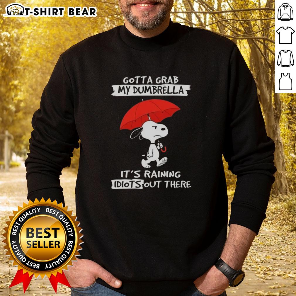 Cozy sweatshirt featuring Snoopy with the phrase 'Gotta Grab My Dumbrella, It's Raining Idiots Out There' perfect for Peanuts fans.