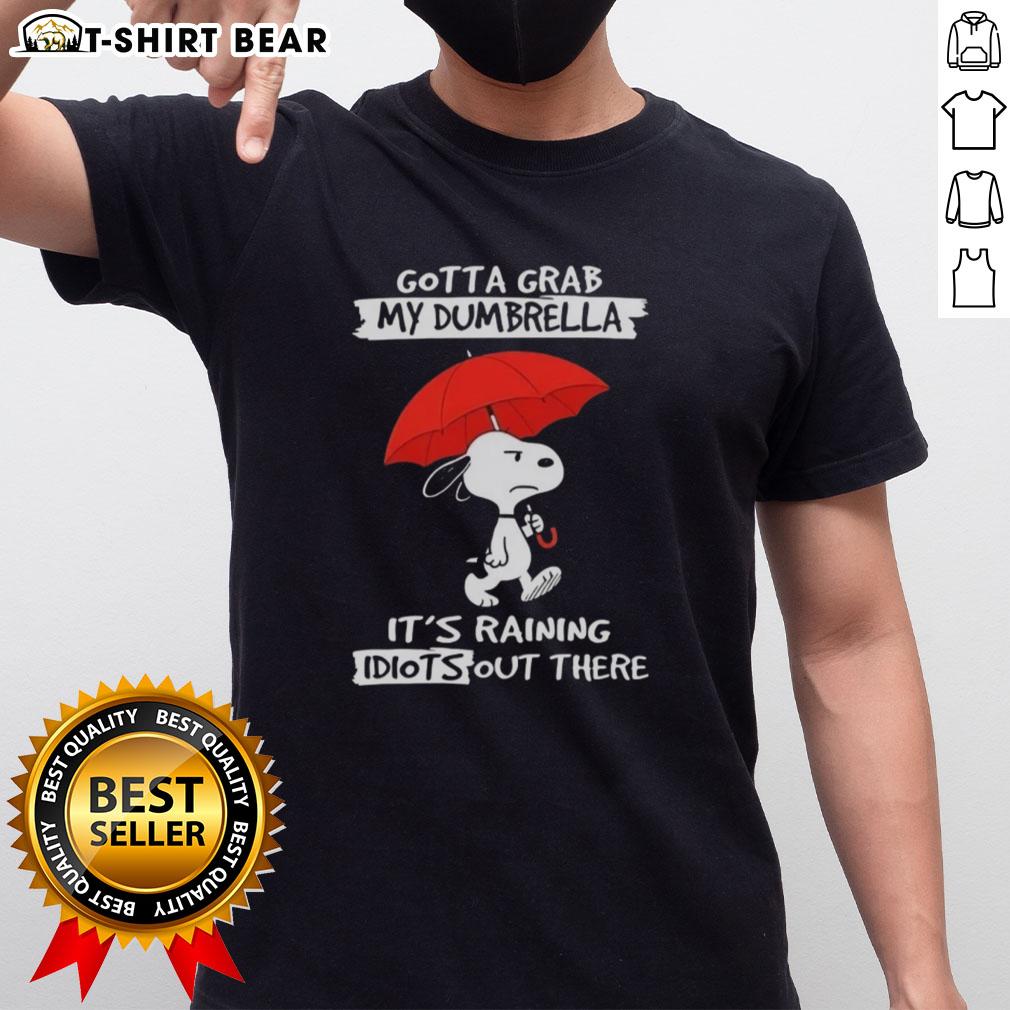 Alt Text: Top Peanuts Snoopy 'Gotta Grab My Dumbrella It's Raining Idiots Out There' T-Shirt featuring Snoopy design.