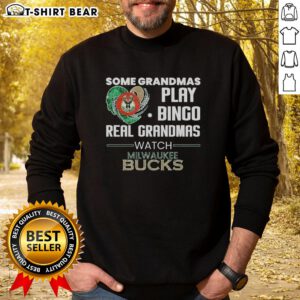 Grandmas enjoying bingo in Milwaukee Bucks sweatshirt, showcasing fun and team spirit in a cozy setting.