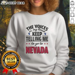 Alt Text: Stylish Hot: The Voices In My Head Keep Telling Me To Go To Nevada sweatshirt displayed on a wooden background.