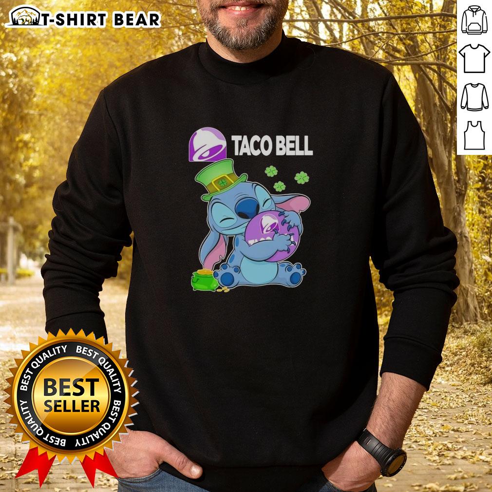 Happy St. Patrick's Day sweatshirt featuring a cute stitch hugging the Taco Bell logo, perfect for festive celebrations.