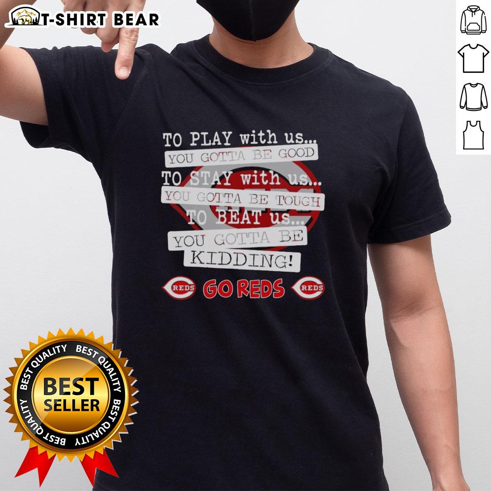 Alt Text: Cincinnati Reds 'To Play With Us You Gotta Be Good' T-shirt featuring team logo and bold graphics for fans.
