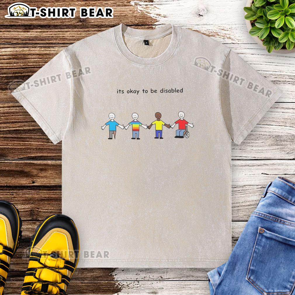 Cartoon design on a washed t-shirt with the phrase 'Good, It's Okay to Be Disabled' promoting disability acceptance.