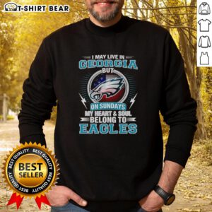 Alt Text: Official Philadelphia Eagles sweatshirt with I May Live in Georgia, But My Heart Belongs to Eagles slogan.