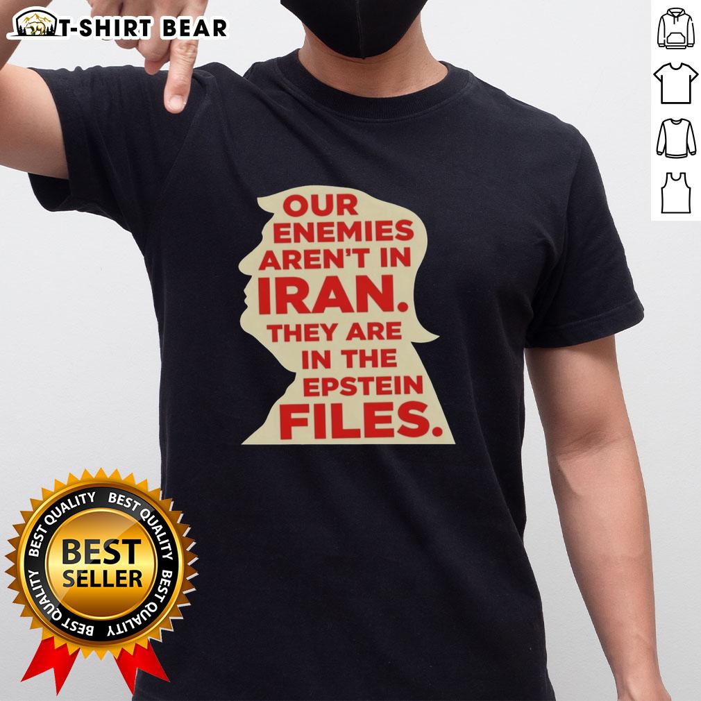 Alt Text: Top Our Enemies Aren't In Iran They Are In The Epstein Files T-Shirt design featuring bold text and graphic elements.