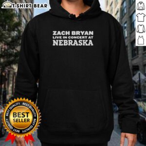 Zach Bryan performing live in Nebraska, wearing a hoodie, captivating the audience at his concert.