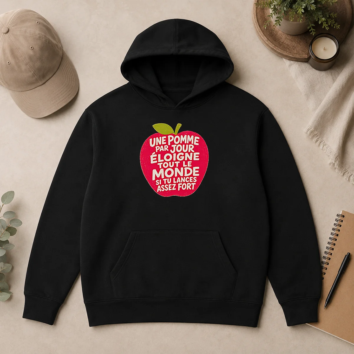 Premium Good Une Pomme Par Jour Eloigne Tout Le Monde Si Tu Lances Assez Fort Humor Hoodie Premium Good Une Pomme Par Jour Eloigne Tout Le Monde Si Tu Lances Assez Fort Humor Hoodie in black, front view with drawstring hood and kangaroo pocket