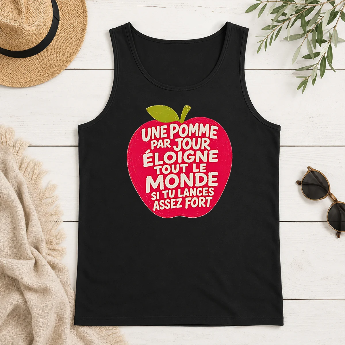 Premium Good Une Pomme Par Jour Eloigne Tout Le Monde Si Tu Lances Assez Fort Humor Tank Top Premium Good Une Pomme Par Jour Eloigne Tout Le Monde Si Tu Lances Assez Fort Humor tank top in white, front view with bold text design